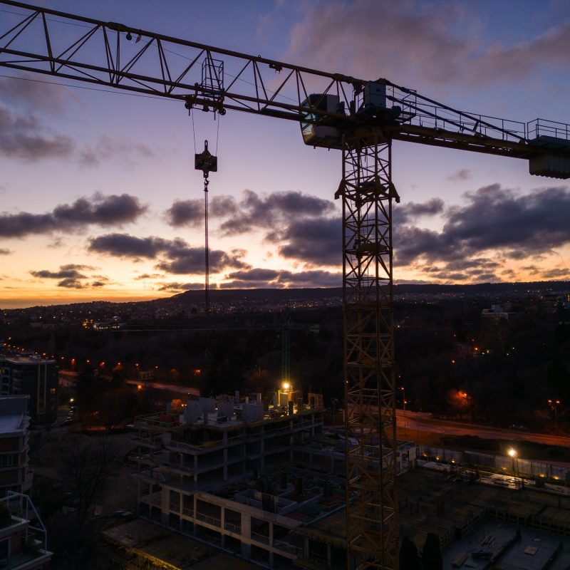 Busy Construction Site and Construction Equipment at night. Aerial view